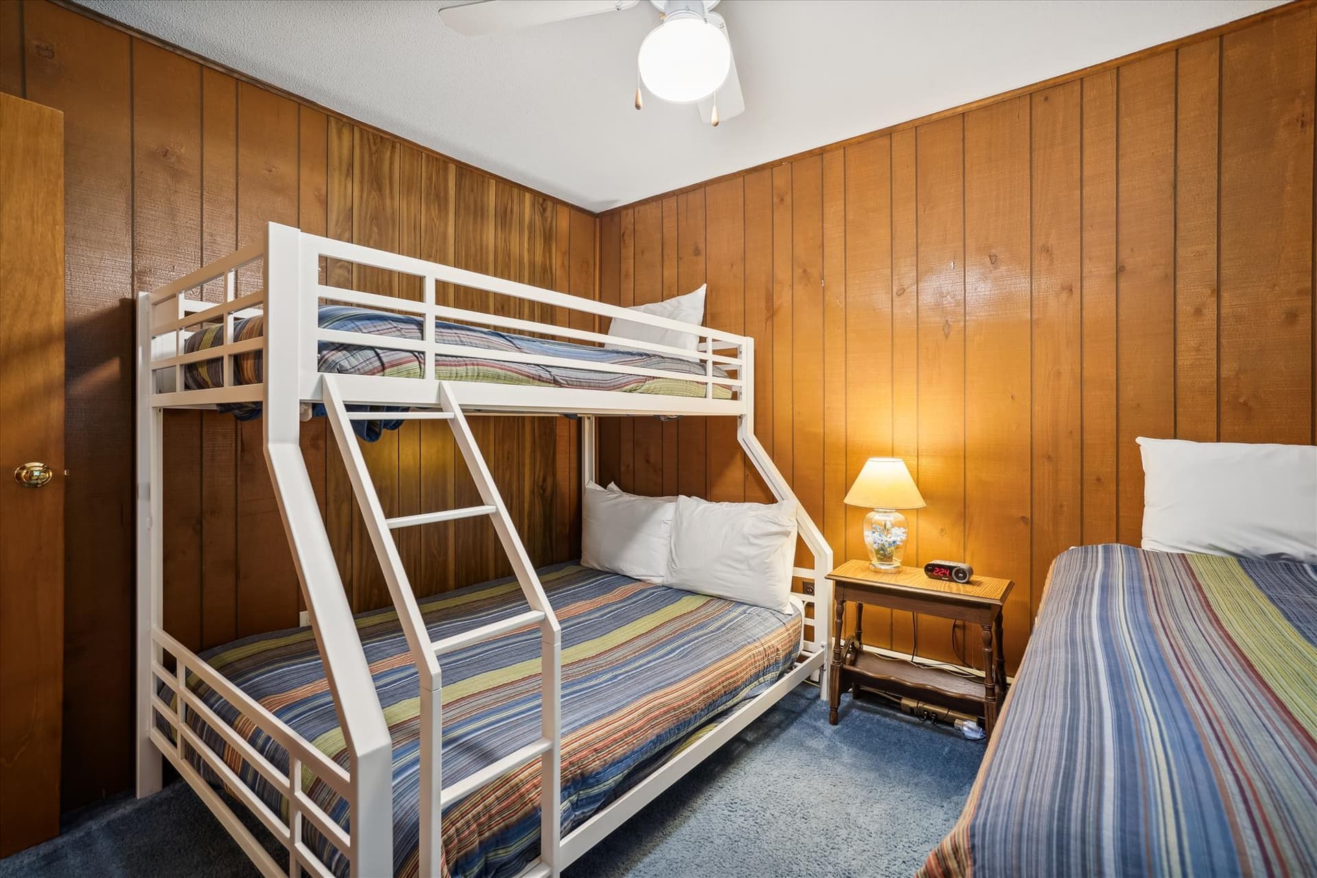 This bedroom has bunk beds and an additional twin bed.