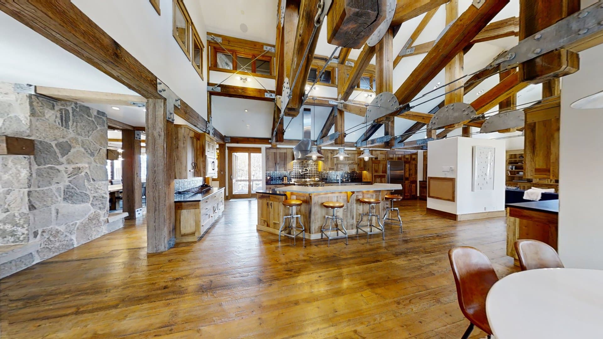 The expansive kitchen space of Talus Ridge with island and bar seating, oven range, and tables.