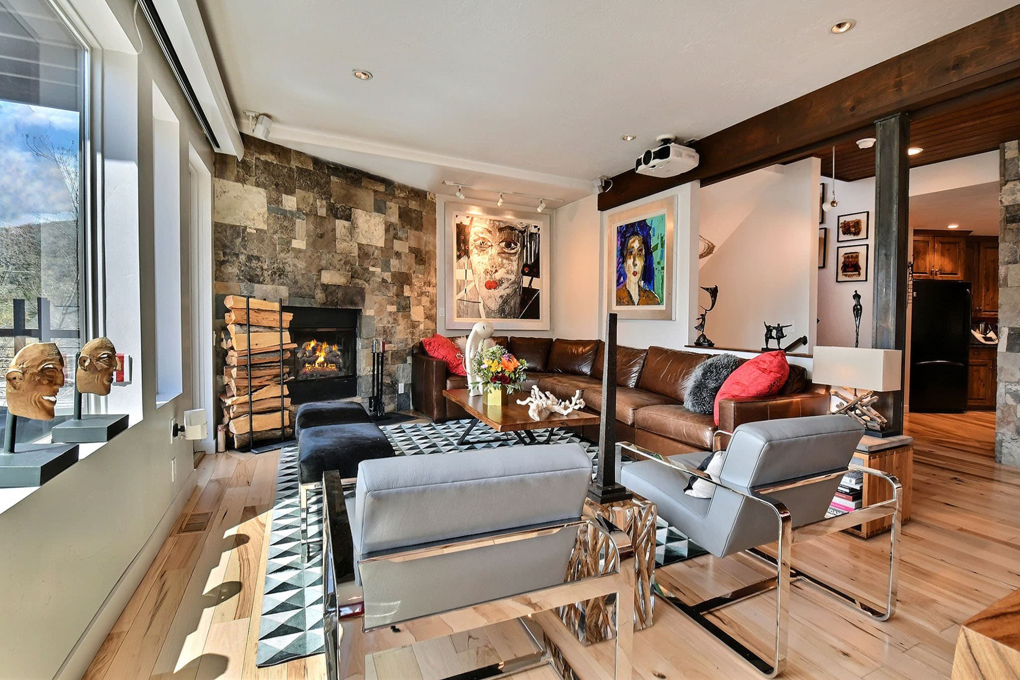 Leather Couch, Two Paintings, and Fireplace inside Main Street Retreat