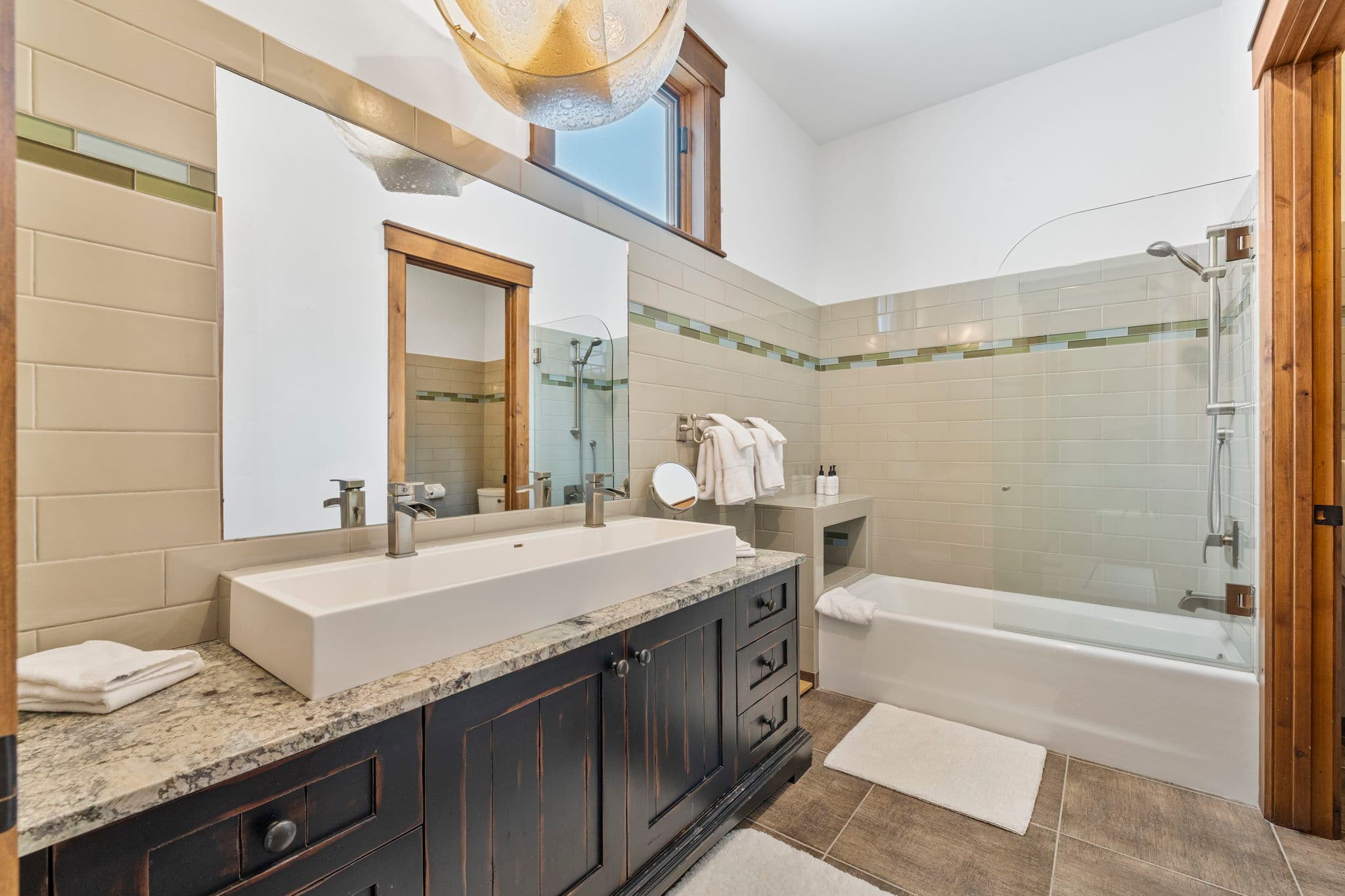 guest en suite bathroom with large sink and double faucets and a tub and shower