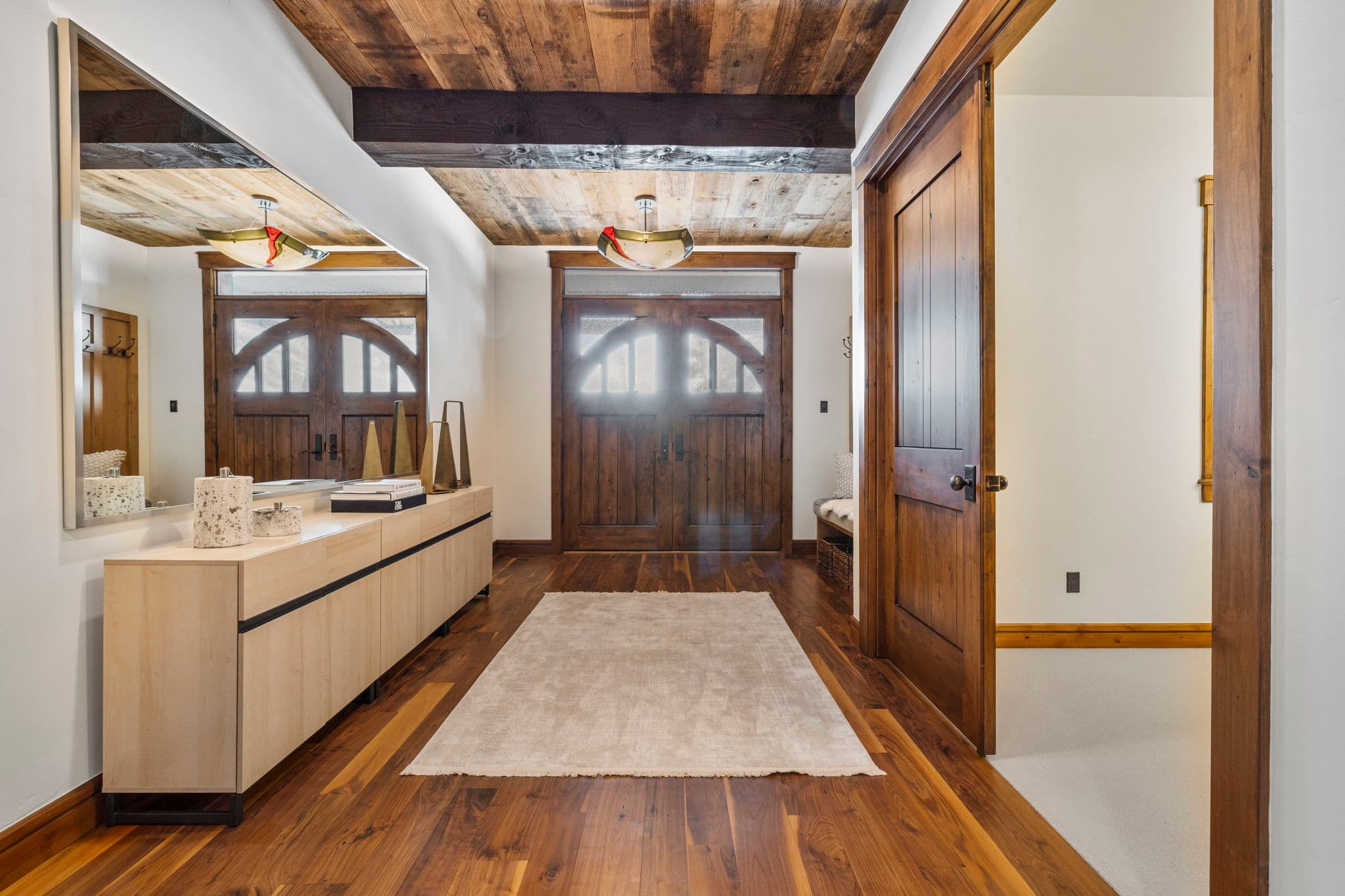 main entrance with large mirror and seating near the door and a chandelier