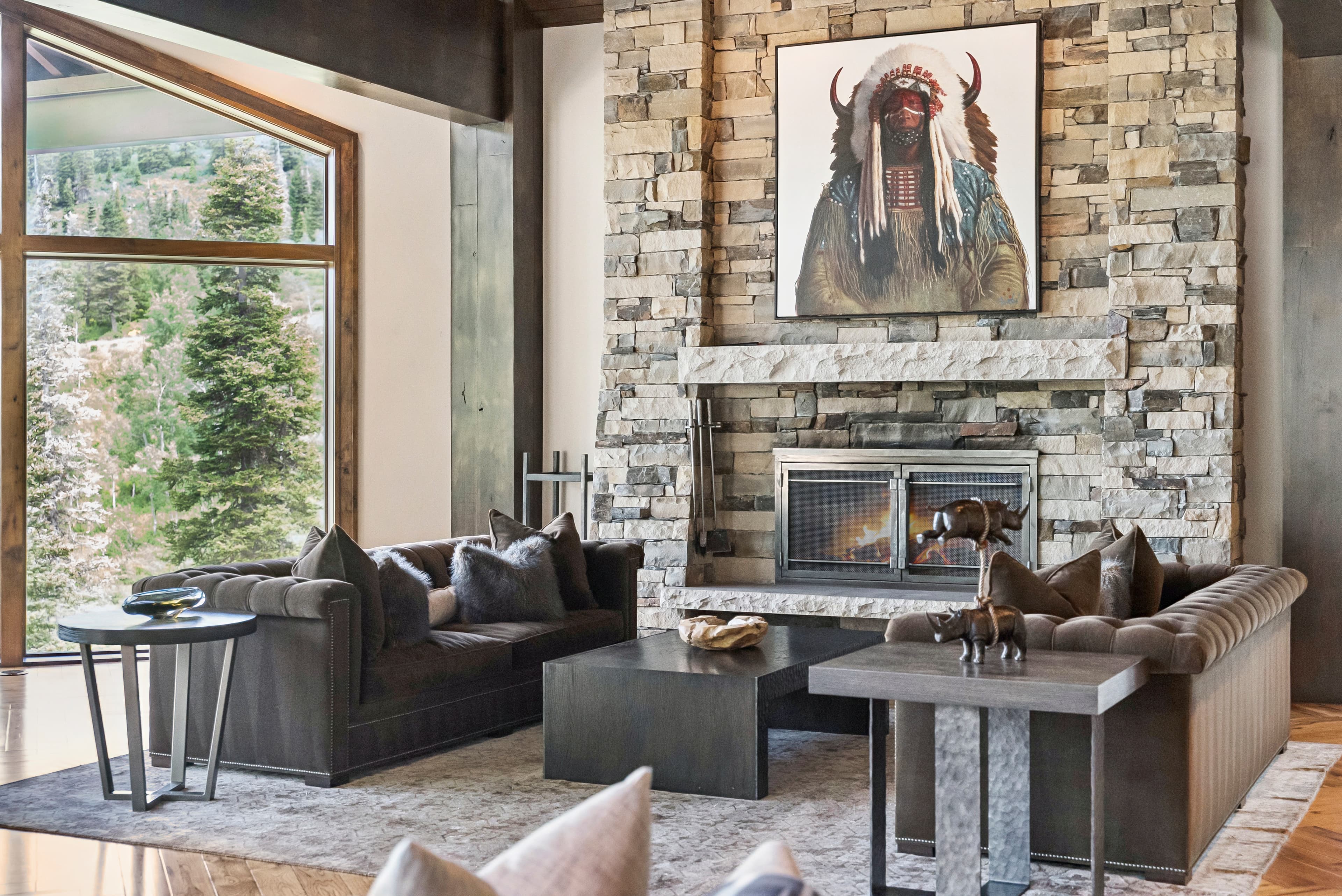 a stunning seating area with overstuffed couches, a large fireplace and stunning artwork above the mantle