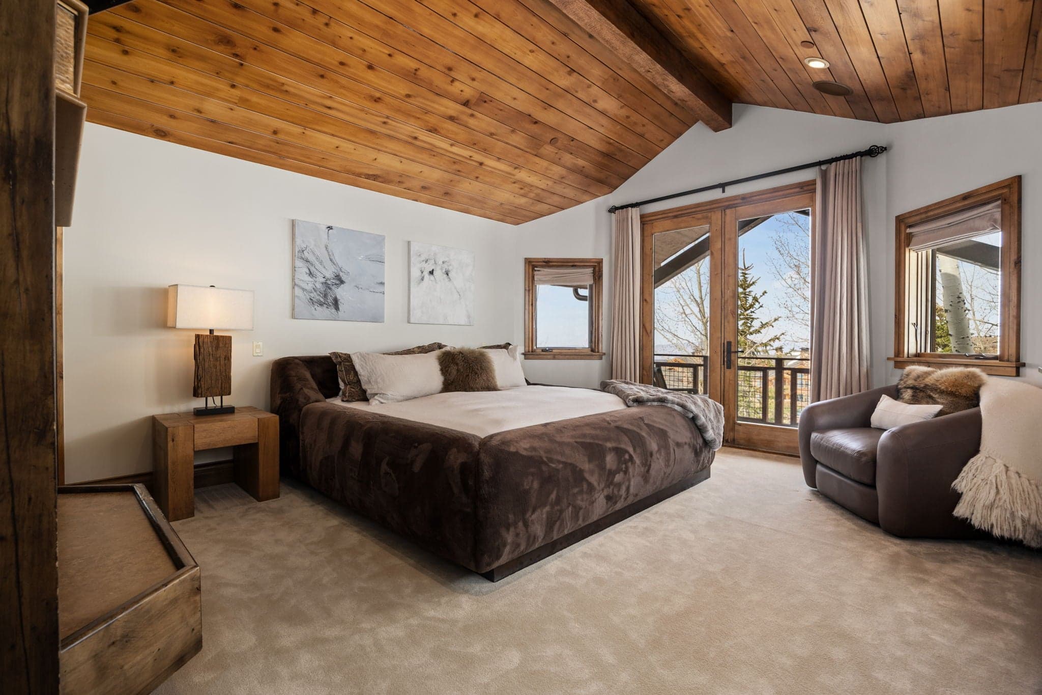 large bed and views of the mountains from the windows in the primary suite