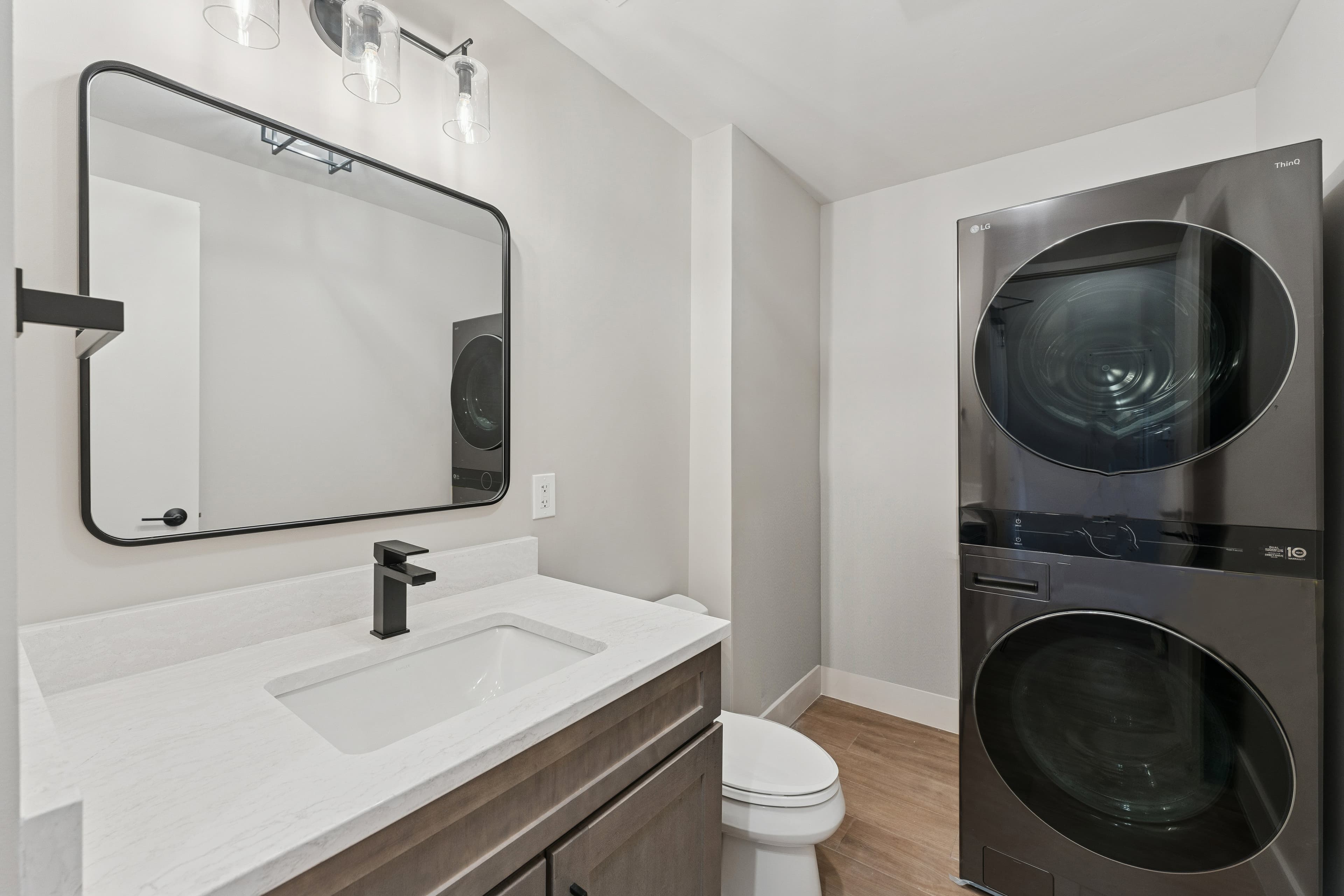 In-unit laundry room with stacked washer-dryer and full guest bathroom in a Park City rental.